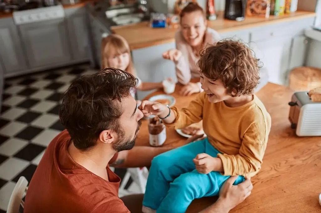 A family laughs together while having breakfast, now that they are protected with Life Insurance.