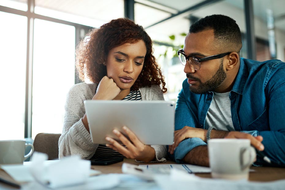 man and woman looking at tablet