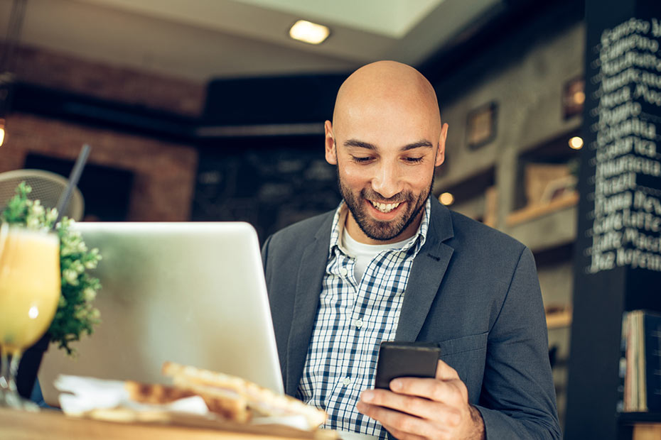 A man looking at his phone and smiling.