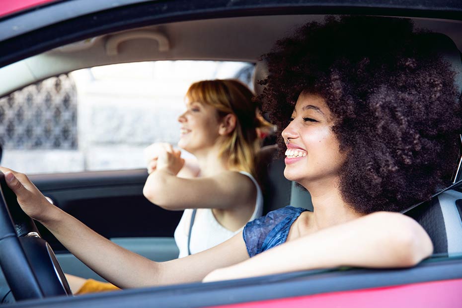 Two young women driving in a car