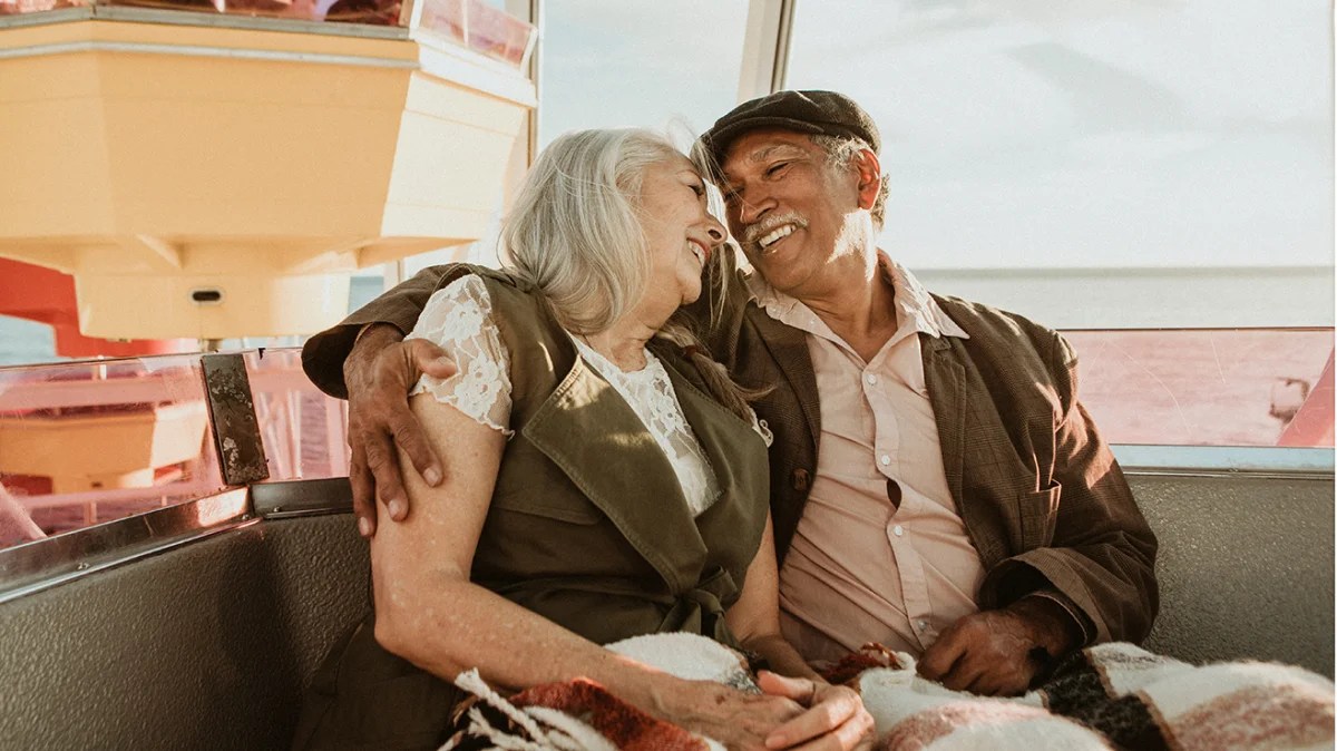 Un couple âgé souriant et s'enlaçant, heureux de sa décision de rente collective