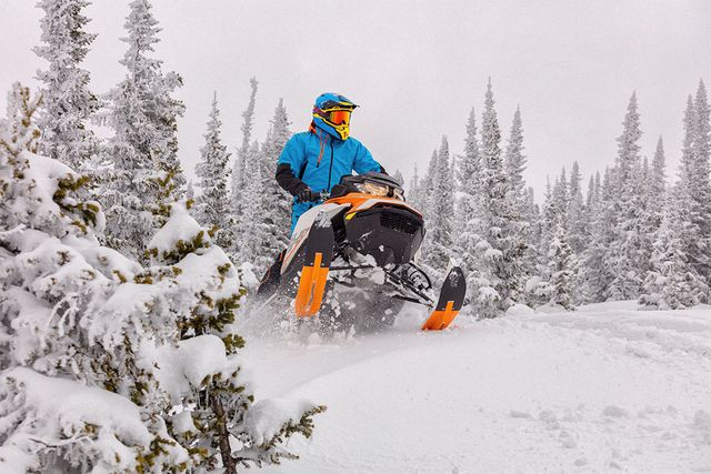 Snowmobile going over hill