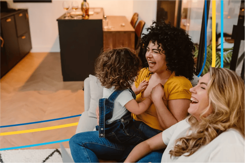 Image d’une famille installée sur un canapé qui rit ensemble